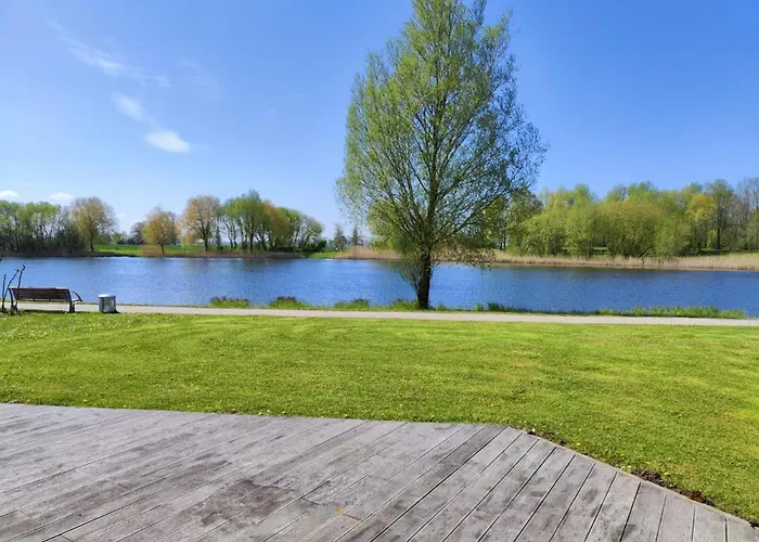 6 Personen Ferienhaus in 1. Reihe zum See mit Kanu und herrlichem Seeblick, Sauna, Whirlpool, Kaminofen, Klimaanlage und E-Tankstelle am Haus in Otterndorf